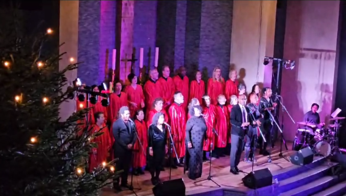 Der ONE VOICE GOSPEL CHOIR BERLIN steht vor dem Altar der GAK, zusammen mit den Solosängern.