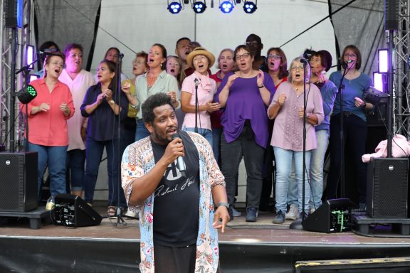 Shon Abram und der ONE VOICE GOSPEL CHOIR BERLIN im Hintergrund auf der Bühne