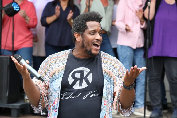 Shon Abram und der ONE VOICE GOSPEL CHOIR BERLIN im Hintergrund auf der Bühne
