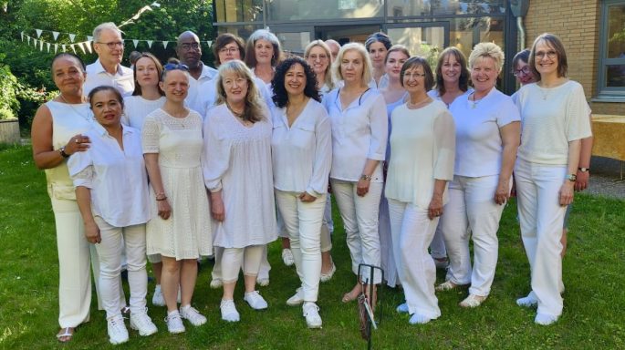 Die Mitglieder des ONE VOICE GOSPEL CHOIR BERLIN stehen als Gruppe vor dem Veranstaltungsort.