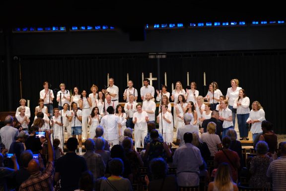 Der ONE VOICE GOSPEL CHOIR und The Gospel Friends stehen zusammen auf der Bühne und singen gemeinsam.