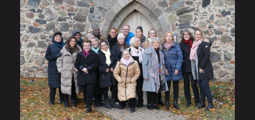 Der ONE VOICE GOSPEL CHOIR BERLIN vor der kleinen Feldsteinkirche in Brusendorf, Brandenburg