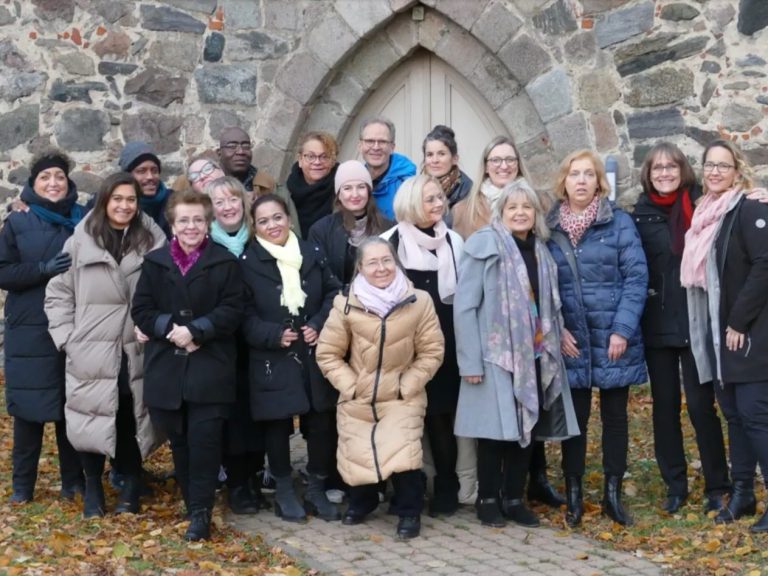 Gruppenfoto des ONE VOICE GOSPEL CHOIR BERLIN vor der kleinen Kirche in Brusendorf